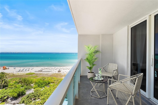 balcony featuring a water view and a view of the beach