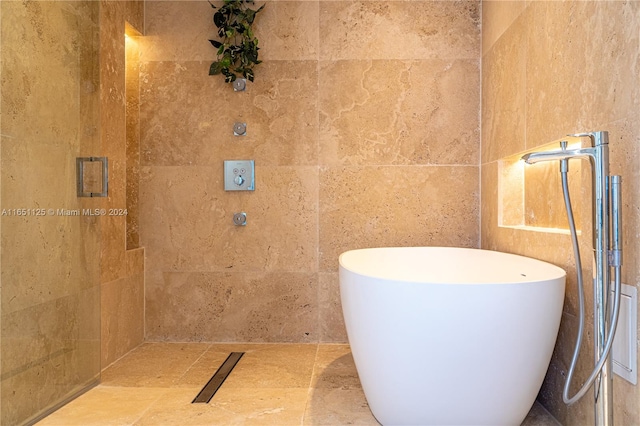 bathroom featuring tile walls, a bathing tub, and sink