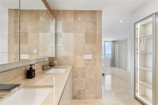 bathroom featuring tile walls, vanity, and a shower