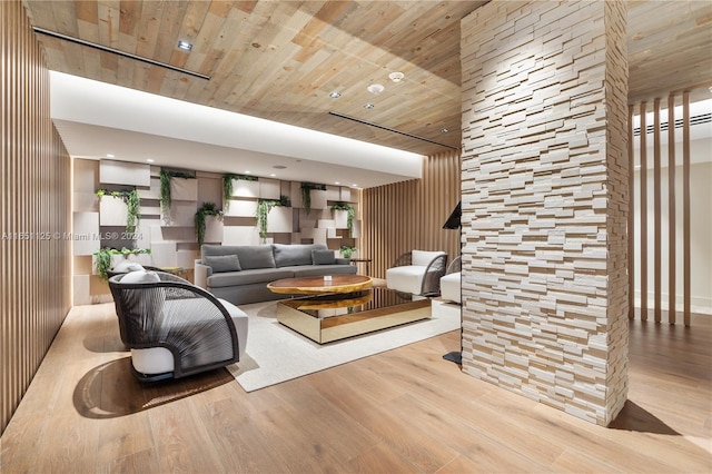 living room with wood walls, wooden ceiling, and light hardwood / wood-style floors