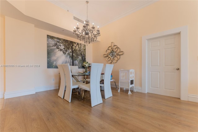 dining space featuring wood-type flooring, an inviting chandelier, and crown molding