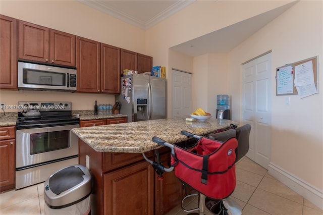 kitchen featuring light stone countertops, a center island, crown molding, light tile patterned flooring, and appliances with stainless steel finishes