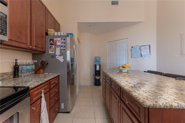 kitchen featuring stainless steel fridge with ice dispenser, light stone counters, and light tile patterned flooring