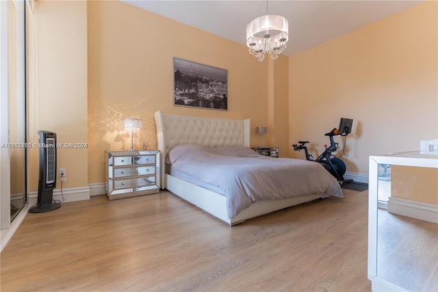 bedroom with a chandelier and light hardwood / wood-style flooring