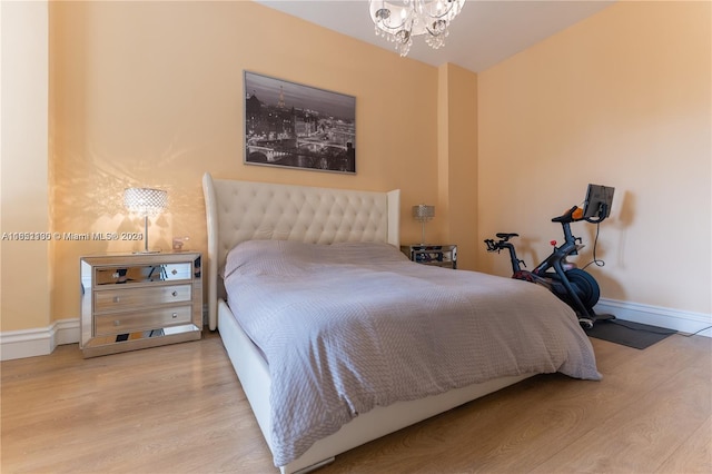 bedroom featuring hardwood / wood-style flooring and an inviting chandelier