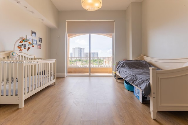 bedroom featuring light hardwood / wood-style floors and access to outside