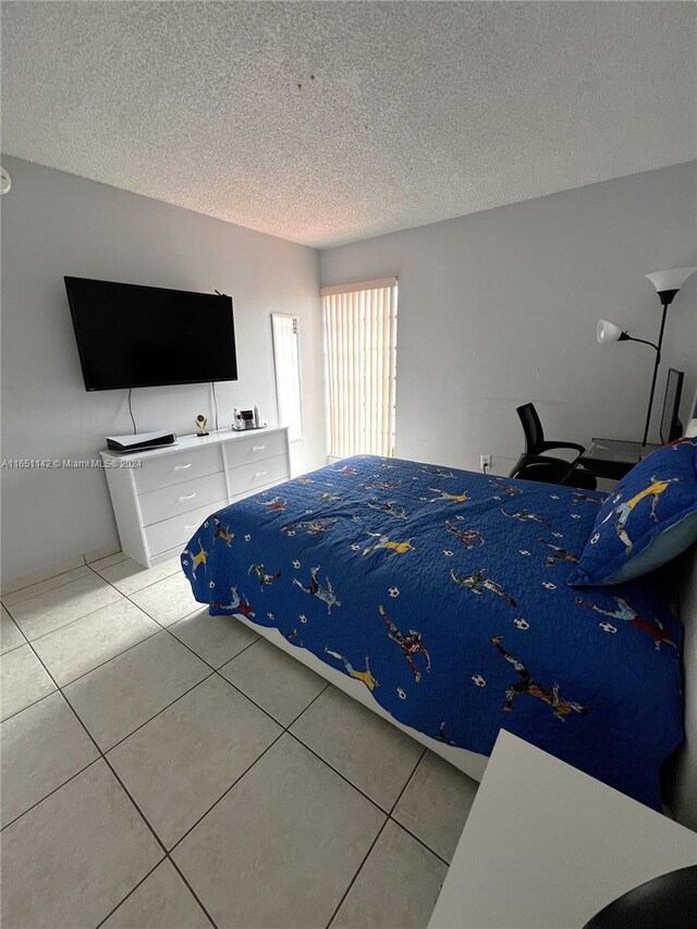 bedroom featuring a textured ceiling and light tile patterned floors