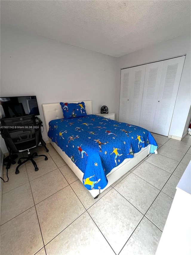 tiled bedroom featuring a closet and a textured ceiling