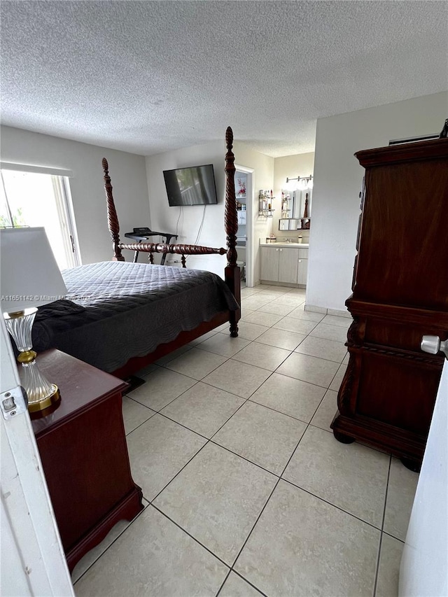 tiled bedroom with ensuite bath and a textured ceiling