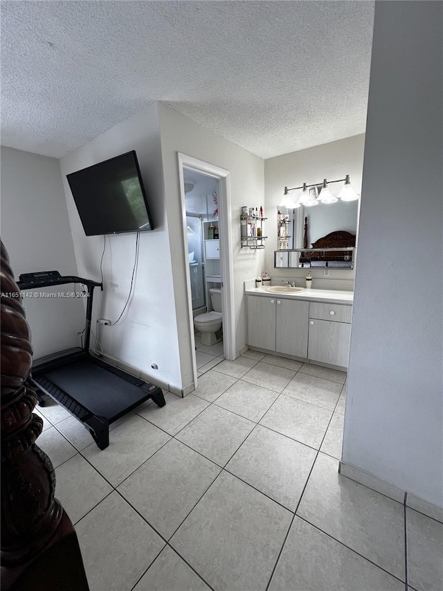 interior space featuring a textured ceiling, sink, and light tile patterned floors