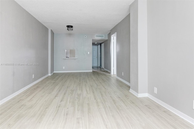 unfurnished living room with light hardwood / wood-style floors and a textured ceiling