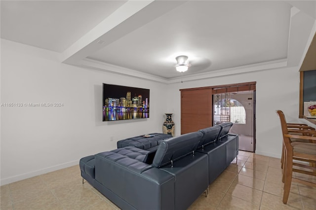 living room featuring a raised ceiling, tile patterned floors, and ceiling fan