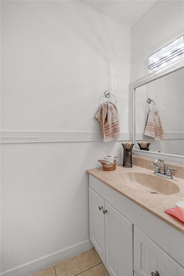 bathroom with tile patterned floors, vanity, and a textured ceiling