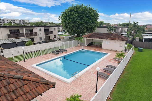 view of pool featuring a lawn and a patio area