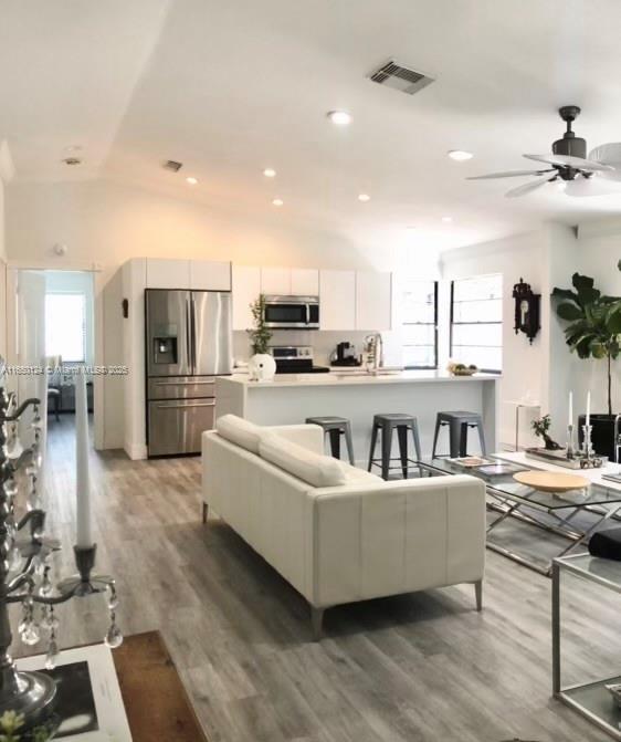 23304 SW 58th Ave Unit B, Boca Raton, FL 33428 - living room featuring light wood-type flooring, a ceiling fan, vaulted ceiling, and recessed lighting