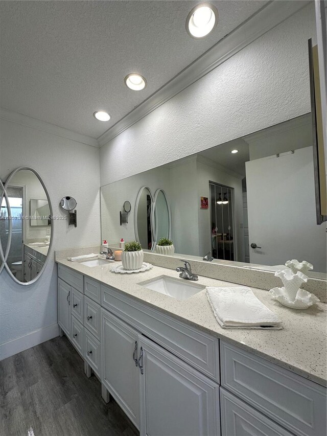 23304 SW 58th Ave Unit B, Boca Raton, FL 33428 - bathroom with a textured ceiling, double vanity, wood finished floors, crown molding, and baseboards
