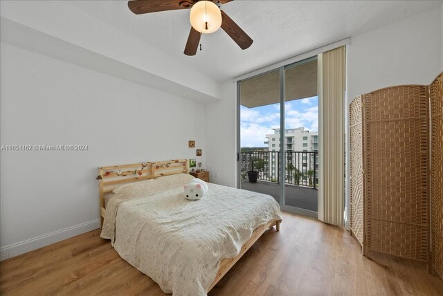 bedroom with access to exterior, ceiling fan, light hardwood / wood-style flooring, and floor to ceiling windows