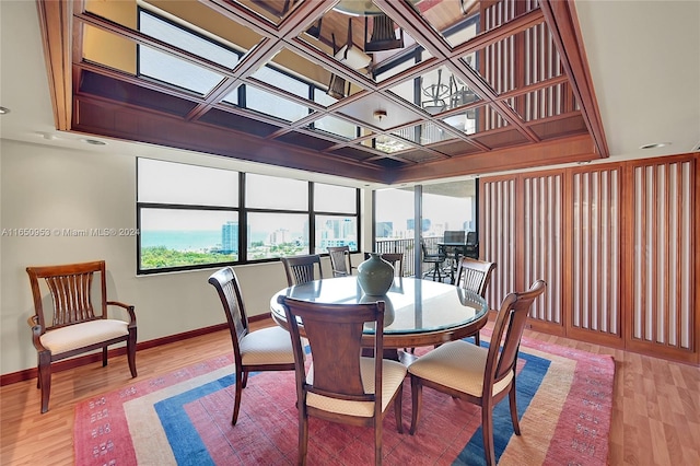 dining space with hardwood / wood-style floors and coffered ceiling