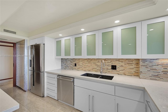 kitchen featuring decorative backsplash, sink, crown molding, stainless steel appliances, and white cabinets