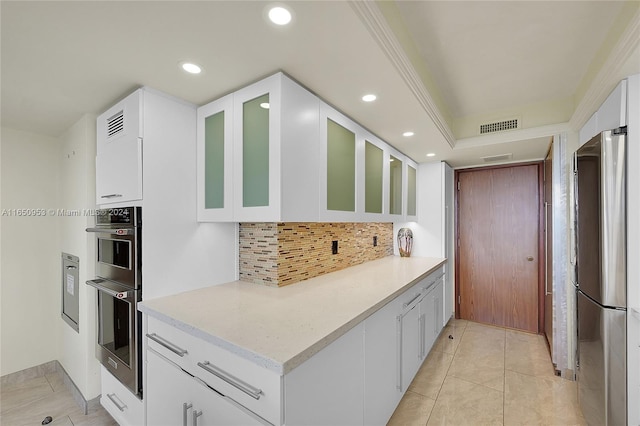 kitchen featuring light tile patterned floors, white cabinetry, stainless steel appliances, and tasteful backsplash