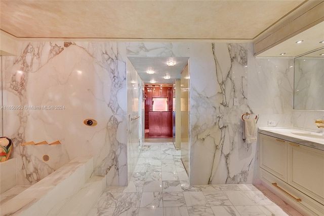 bathroom with tile walls, vanity, and ornamental molding