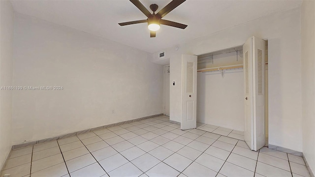 unfurnished bedroom featuring ceiling fan, light tile patterned flooring, and a closet