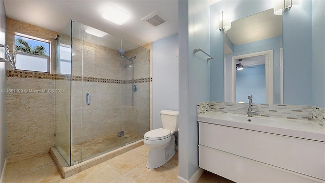 bathroom featuring tasteful backsplash, vanity, ceiling fan, a shower with door, and toilet