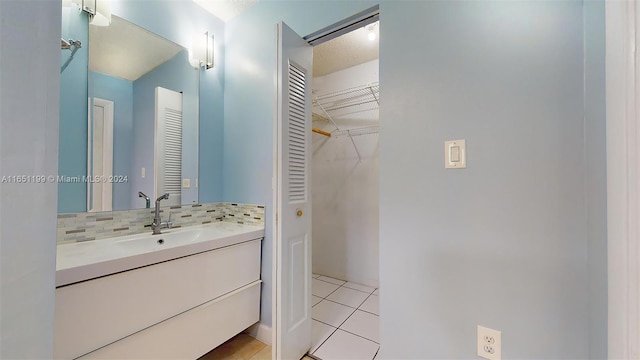 bathroom with backsplash, tile patterned flooring, and vanity