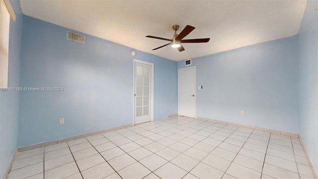 unfurnished room featuring a textured ceiling, light tile patterned floors, and ceiling fan