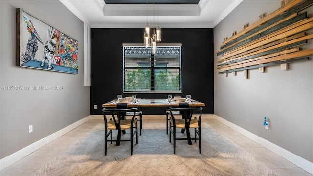 dining space featuring crown molding, a tray ceiling, and tile patterned flooring