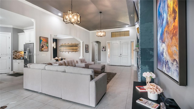 living room with light tile patterned floors, a notable chandelier, and ornamental molding