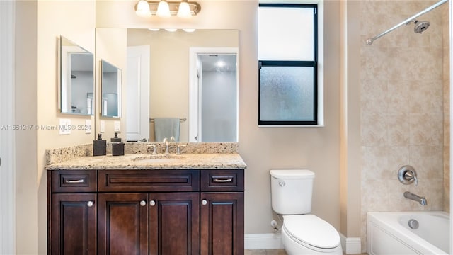 full bathroom featuring tiled shower / bath, toilet, and vanity