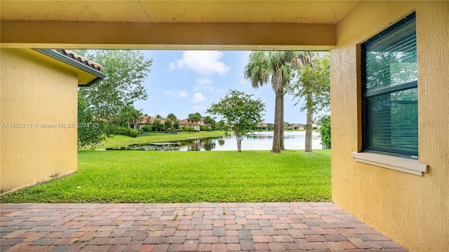 view of yard with a water view and a patio