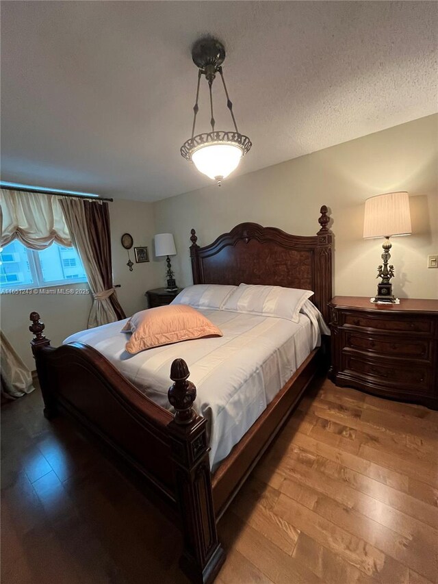 bedroom featuring a textured ceiling and wood finished floors