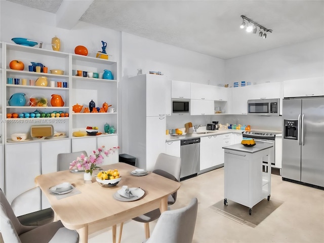 kitchen with white cabinetry, appliances with stainless steel finishes, a center island, and sink