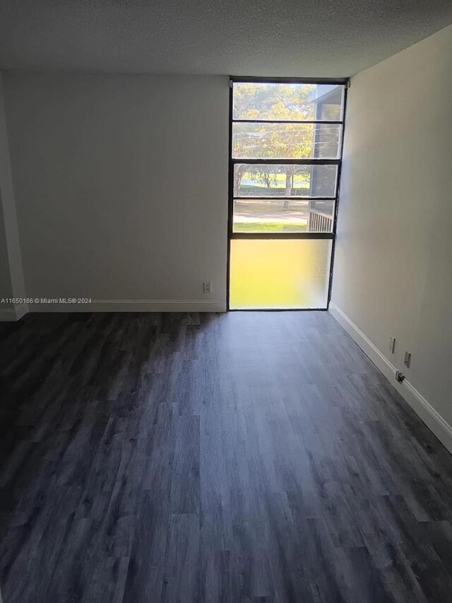 3475 N Country Club Dr Unit 204, Aventura, FL 33180 - empty room featuring dark wood-style floors, baseboards, and a textured ceiling