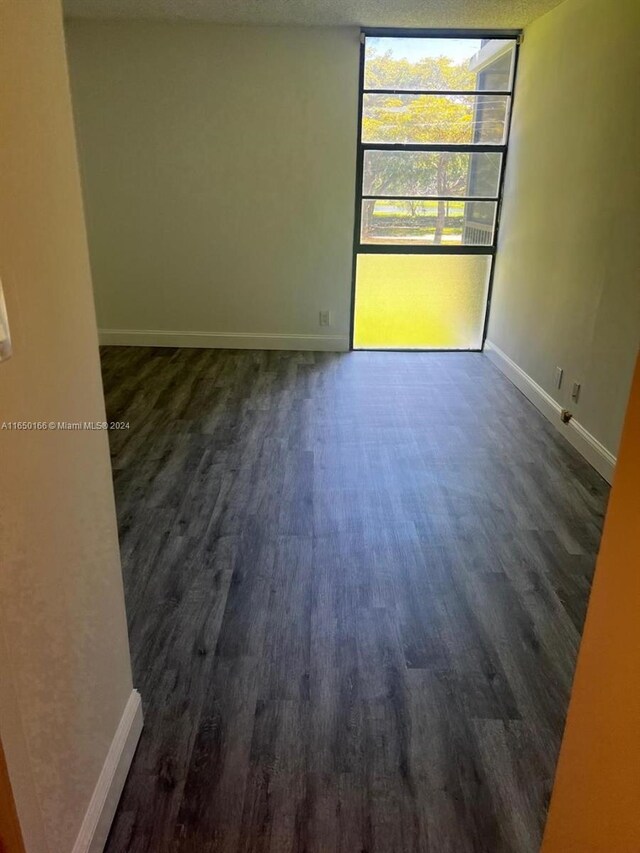 3475 N Country Club Dr Unit 204, Aventura, FL 33180 - unfurnished room with dark wood-style flooring, baseboards, and a wall of windows