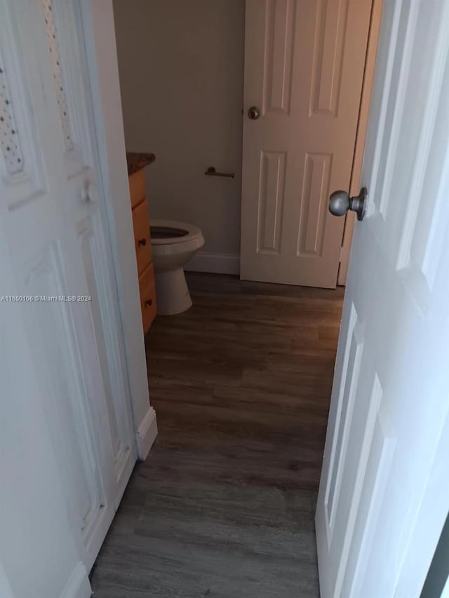 bathroom with vanity, toilet, and wood-type flooring