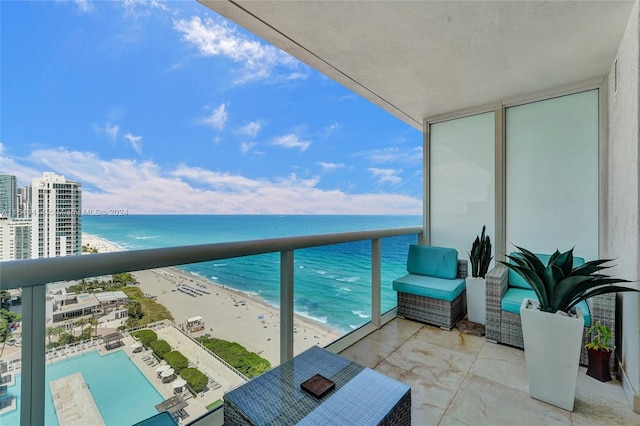 balcony featuring a water view and a view of the beach