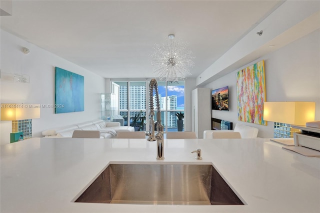 kitchen with expansive windows, sink, and a notable chandelier