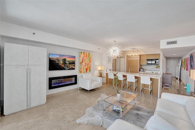 living room featuring sink and a chandelier