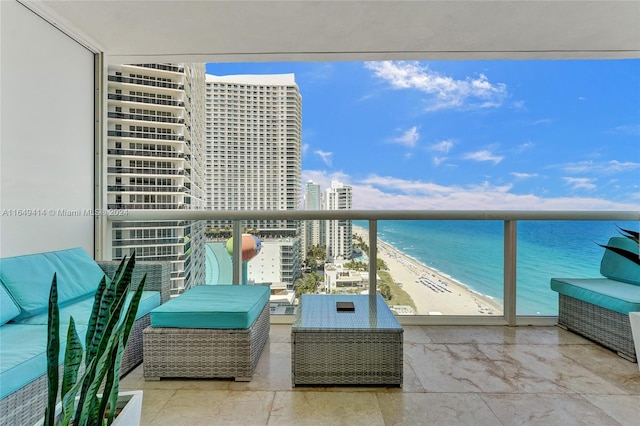 balcony featuring a view of the beach and a water view