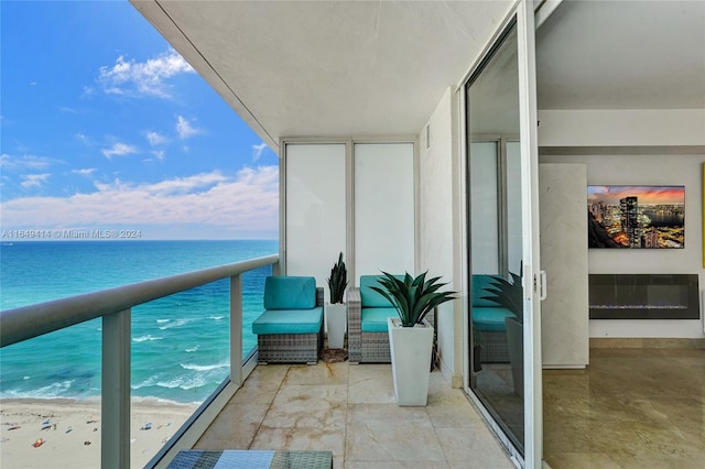 balcony featuring a view of the beach and a water view