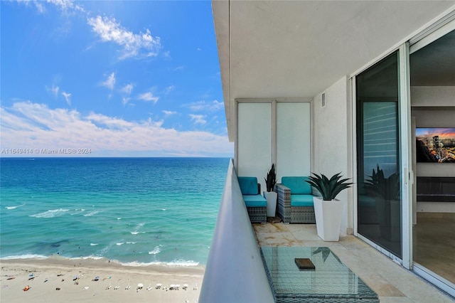 balcony featuring a beach view and a water view