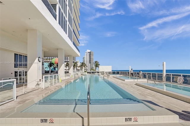 view of swimming pool featuring a patio area and a water view