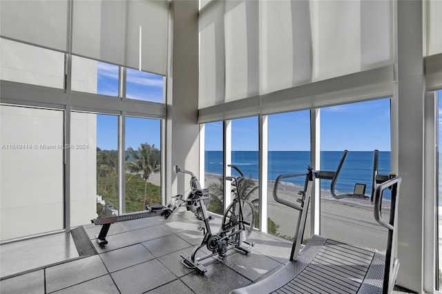 gym with a water view and a towering ceiling