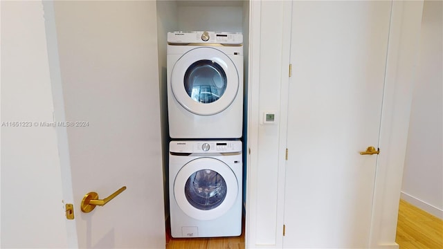 laundry area featuring light wood-type flooring and stacked washing maching and dryer