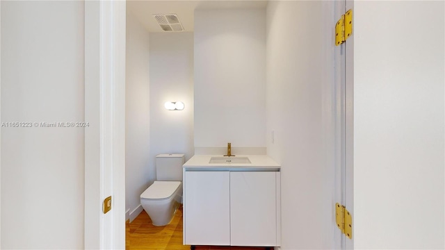 bathroom featuring vanity, toilet, and hardwood / wood-style floors