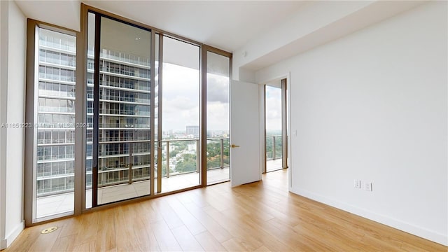 spare room with light wood-type flooring and expansive windows