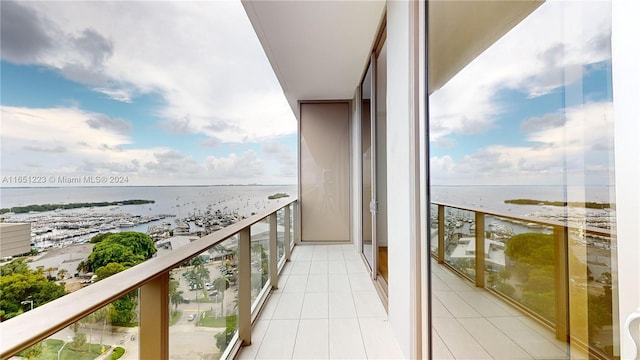 balcony with a water view and a view of the beach